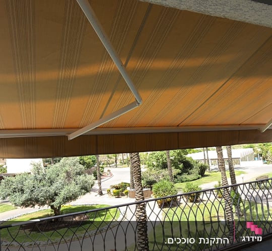 מרפסת עם סוכך חום ונוף עצים